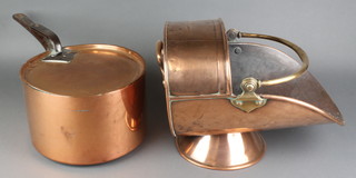 A circular copper saucepan with iron handle 10" and a copper helmet shaped coal scuttle