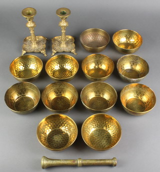 A pair of 19th Century Continental gilt metal candlesticks with shaped bases raised on panel feet 7", a brass pestle and 12 brass finger bowls 4 1/2" diam. 