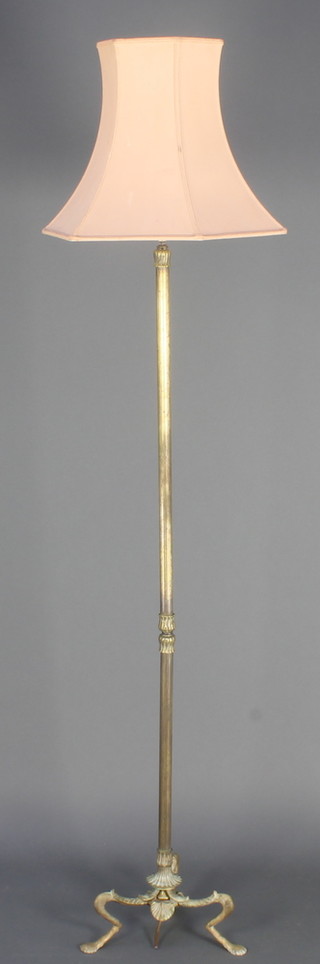 A brass reeded standard lamp raised on 3 hoof feet 