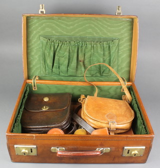 A light brown leather suitcase with brass fittings 6"h x 20"w x 13 1/2"d containing a pig skin briefcase with chrome mounts 11"h x 16"w x 1"d, a brown leather satchel 8" x 8" x 2", a light brown handbag 7" x 8" x 2 1/2, 3 leather stud boxes 