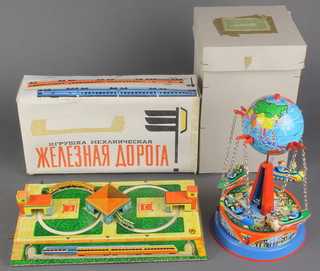 A Japanese tin plate clockwork table top train set 1"h x 9"w x 4 1/2"d boxed and a German tin plate clockwork carousel boxed