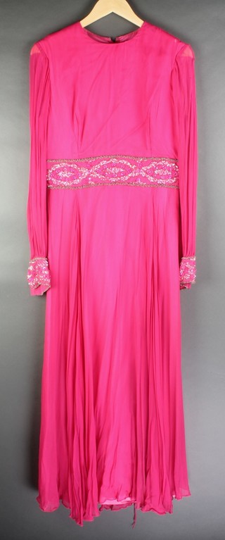 Mayon Couture and Bakes Sportswear of Mayfair, a lady's pink long sleeved evening dress with beadwork detail to the waist and arms, size 16 together with a 1960's gold lame evening dress 