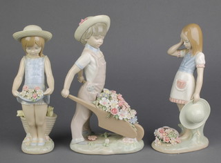 A Lladro figure of a young girl holding flowers in her skirt 7", a ditto of a boy pushing a wheelbarrow of flowers 8" and ditto of a girl with flowers 7" 