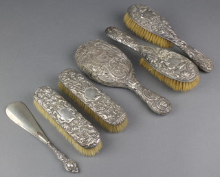 A Victorian silver 4 piece repousse brush set London 1896, a similar hand mirror and shoe horn