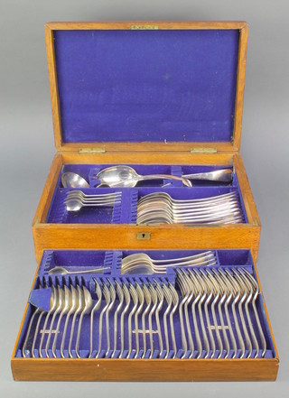 An Edwardian oak canteen containing a matched 55 piece canteen of silver plated cutlery