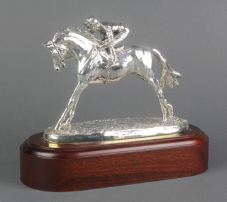 A filled silver trophy in the form of a jockey up, on a wooden plinth 9" 