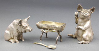 A fine solid silver novelty condiment comprising a pepperette in the form of an upright seated pig 3 1/2", a salt in the form of a seated pig 2 3/42" and a mustard in the form of a rustic trough 2 3/4" with a shovel.  By Richard Comyns London 1990/91, 575 grams Richard Comyns was the son of the renowned silversmith William Comyns 1885-1930
