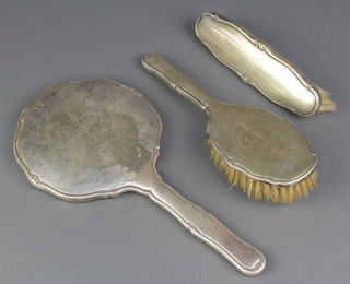 A Continental silver brush set comprising hand mirror, clothes brush and hair brush with engraved monogram 
