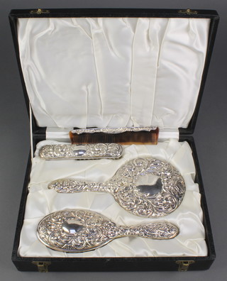 A cased 4 piece repousse silver brush set Birmingham 1974