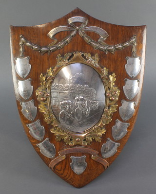 Of cycling interest, a Victorian shield trophy - Horsham Amateur Athletic Club, The Alexander Clark Challenge Trophy, the oak plaque with silver engraved badges 1898 - 1929, surrounding a silver plated repousse panel of a cycling race enclosed in an acorn and oak leaf bronze mount 18" 