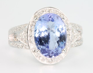 A 14ct white gold tanzanite and oval cluster diamond ring, the centre stone approx 3.8ct surrounded by brilliant cut diamonds approx 0.6ct, size L 1/2