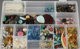 A box of loose stones including garnets, citrines, tanzanites, quartz etc 