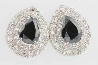 A pair of 18ct white gold treated black pear shaped diamond earrings, the centre stones 7ct surrounded by brilliant cut diamonds approx. 2.2ct 