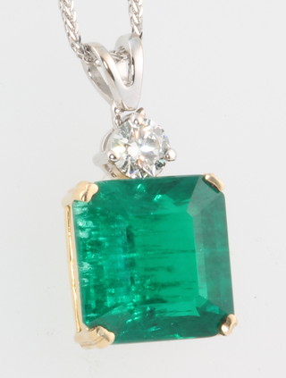A square cut emerald in a yellow gold mount suspended from a single stone diamond, the main stone 6.4ct, the diamond 0.3ct, on a 14ct white gold chain 