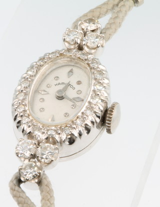 An 18ct white gold diamond set wristwatch, the dial inscribed Hamilton on a silk strap 