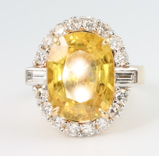 An 18ct yellow gold oval yellow sapphire and diamond ring, the centre stone approx. 8ct size M