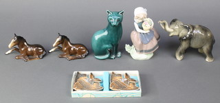A Poole turquoise glazed figure of a seated cat 6 1/2", a porcelain elephant, a Lladro girl holding a basket of flowers and 2 reclining Sylvac horses