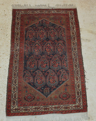 A Persian blue ground rug with diamond shaped medallion to the centre and paisley design 64" x 40" 