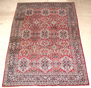A Persian Birjand red and blue ground carpet with all over floral designs, signed 117" x 81"