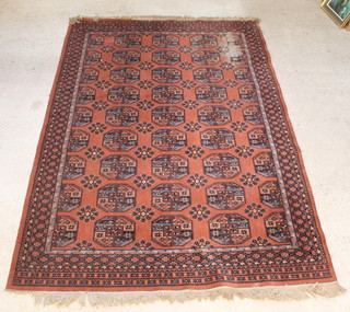 A pink pattern machine made Bokhara style rug with 27 octagons to the centre 137" x 92" 