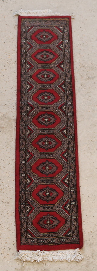 A red and grey ground Uzbek runner with 9 diamonds to the centre 54" x 12" 