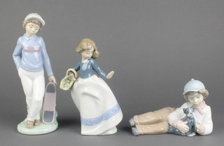 A Nao figure of a boy with skateboard 8 1/2"., ditto of a girl with basket 7" and a reclining boy with puppy 6" 