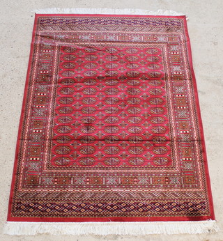 A red ground Bokhara style Belgian cotton rug with 65 octagons to the centre 74" x 54" 

