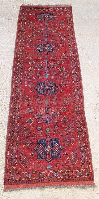 A blue and red ground Afghan runner with 7 medallions to the centre 122" x 37" 