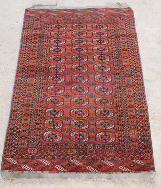 A red ground Tekke ~Torkman Bokhara rug with 6 octagons to the centre 81" x 51" 