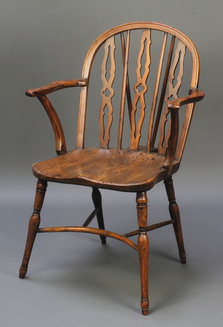 An 18th/19th Century elm hoop back Windsor chair with solid seat and crinoline stretcher raised on  turned supports 
