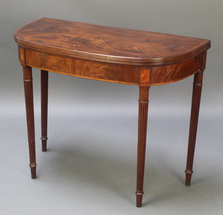 A Georgian mahogany D shaped folding card table with crossbanded top, raised on reeded supports 28 1/2"h x 36"w x 18"d 