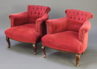 A pair of Edwardian tub back armchairs upholstered in red buttoned material, raised on cabriole supports 