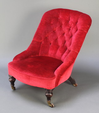 A Victorian tub back chair upholstered in red buttoned material, raised on turned supports
