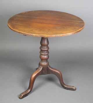 A 19th Century circular oak snap top tea table raised on a turned column and tripod base 29 1/2h x 29" diam. 