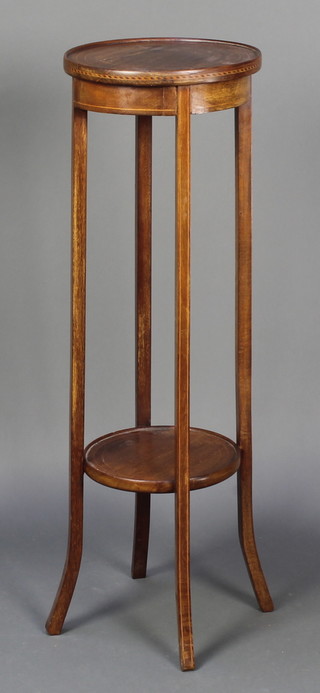 An Edwardian circular mahogany 2 tier jardiniere stand raised on tapered supports 37 1/2"h x 12" diam. 