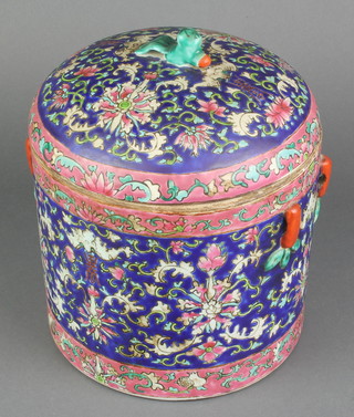 A late 19th Century Chinese circular storage jar and cover, the dark blue ground with formal flowers and pierced handles, the lid with fish finial 8 1/2" 