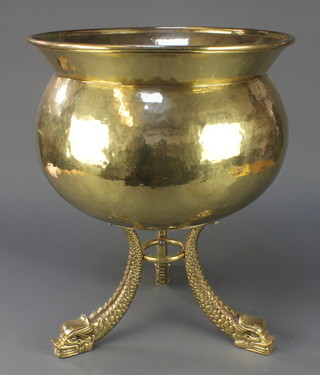 A circular planished brass planter/jardiniere raised on dolphin supports 19"h x 15 1/2" diam. 