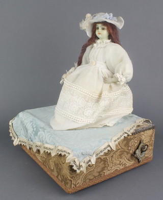 A 19th Century Continental automaton in the form of a bonneted seated girl with turning head and rising arm, raised on a square base 13"h x 9"w x 9 1/2"d 