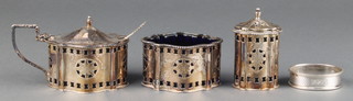 A Georgian style 3 piece silver condiment pierced and engraved decoration salt, mustard and pepper,Makers A Chick & Sons London 1972 blue glass liners, 220 grams and a silver napkin ring