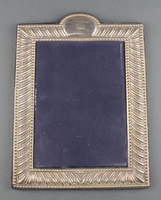 A repousse silver photograph frame with vacant cartouche 10" 