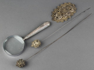 A Persian magnifying glass with silver handle, filigree mount and 2 hat pins 