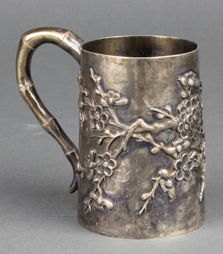 An early 20th Century Chinese silver mug with prunus decoration and bamboo handle 148 grams