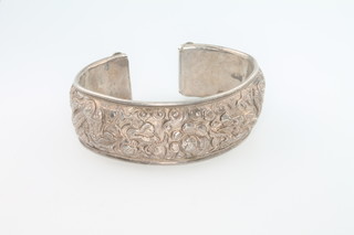 A Chinese silver bangle decorated with dragons and flowers, 57 grams