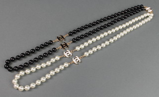 A white and black imitation pearl Chanel style necklace 22" 