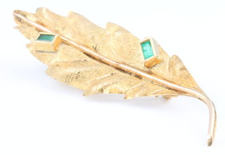 An 18ct yellow gold emerald set leaf shaped brooch 2.4 grams