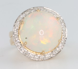 An 18ct yellow gold opal and diamond ring, the centre stone approx. 7.2ct surrounded by brilliant cut diamonds approx. 0.52ct, size N