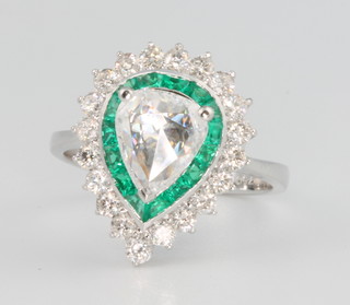 An 18ct white gold pear shaped diamond and emerald ring, the centre stone approx. 1ct surrounded by brilliant cut emeralds approx. 1.26ct and brilliant cut diamonds approx. 0.72ct size N