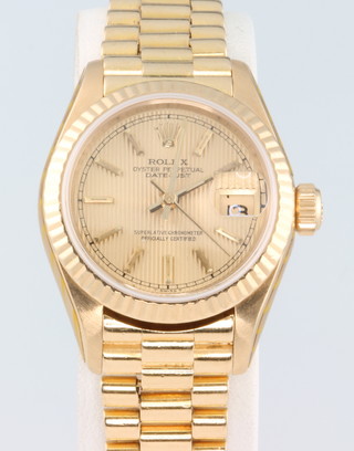 A lady's 18ct yellow gold Rolex Oyster Perpetual Datejust wristwatch on an 18ct yellow gold presidential bracelet with concealed clasp together with a velvet pochette and Rolex service invoice 2015 