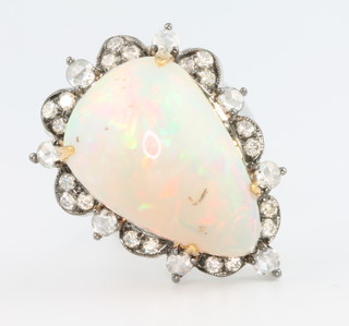 A 15ct white gold pear cut opal and diamond ring, the centre stone approx. 14.08ct surrounded by 9 brilliant cut diamonds size N 1/2