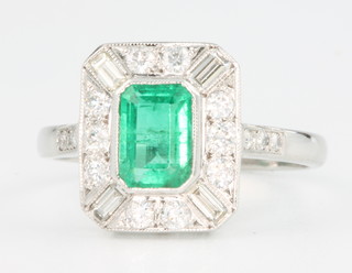 An 18ct white gold Art Deco style emerald and diamond ring, the centre stone approx. 0.6ct surrounded by baguette and brilliant cut diamonds approx 1.1ct, size O 1/2